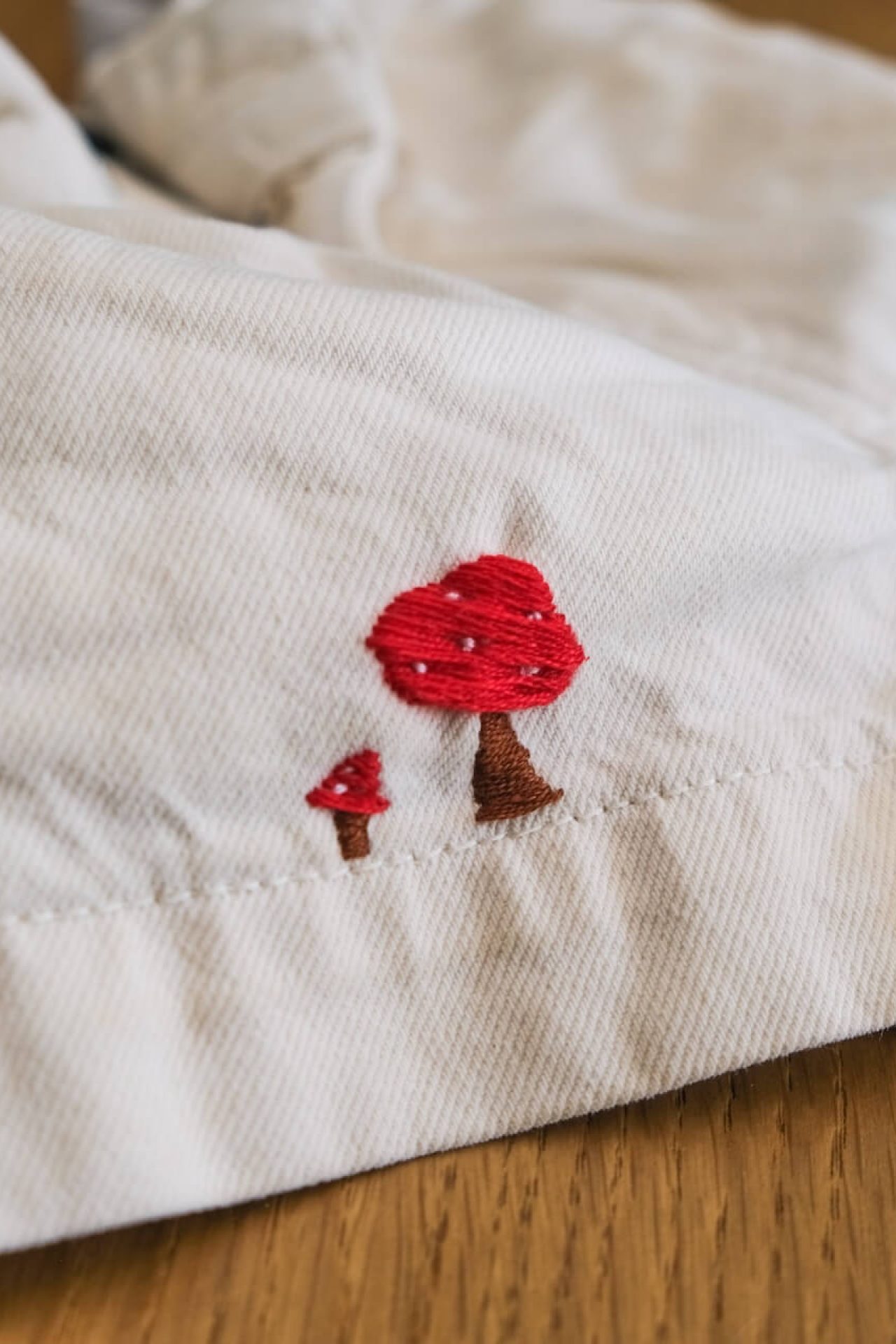 Deux champignons rouges brodés sur un short blanc